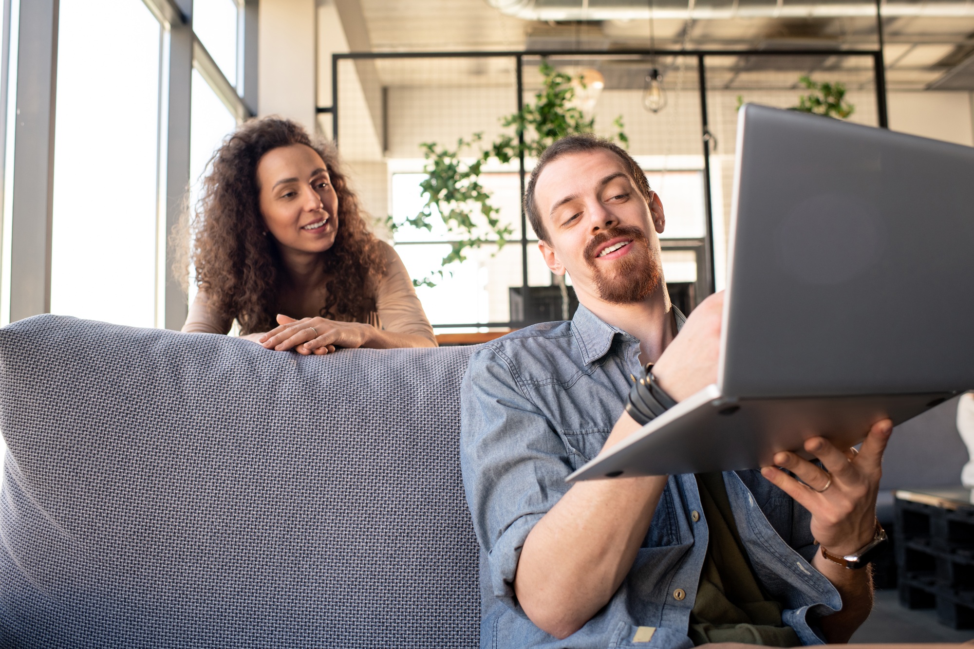 young smiling bearded man showing his wife new equipment for their restaurant.jpg